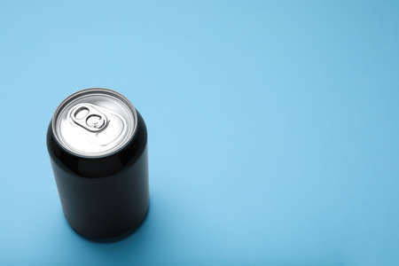 Black can of energy drink on light blue background. Space for textの写真素材
