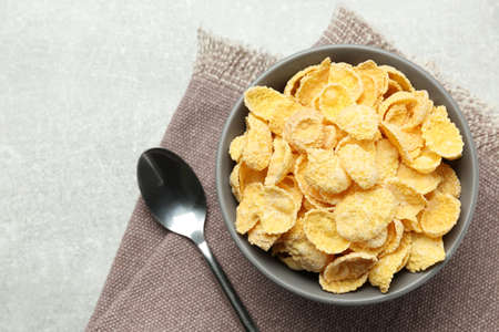 Bowl of sweet crispy corn flakes on light gray table, flat lay. breakfast cerealの写真素材