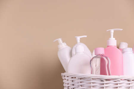 Baby cosmetic products in wicker basket on beige background, closeup. Space for textの写真素材