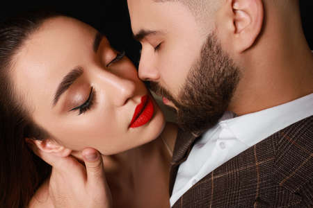 Handsome bearded man with sexy lady on black background, closeupの写真素材