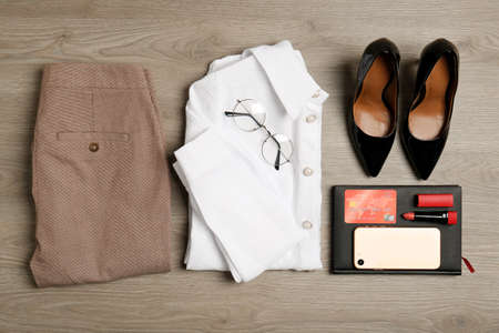 Flat lay composition with clothes, shoes and accessories on wooden background. Packing for business tripの写真素材