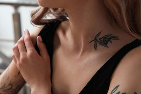 Beautiful woman with tattoos on body indoors, closeupの写真素材