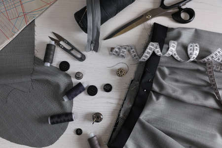 Set of sewing supplies and accessories with fabric on white wooden table, flat layの写真素材