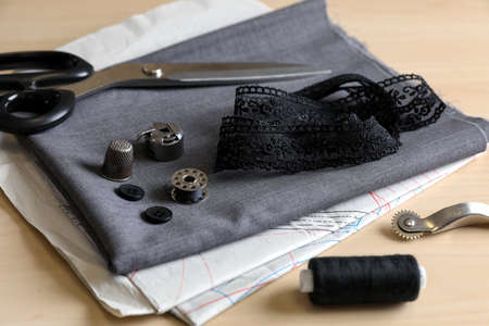 Set of sewing supplies and accessories with fabric on wooden tableの写真素材