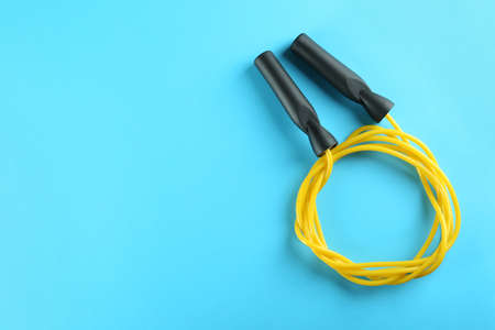Skipping rope on light blue background, top view. Space for textの写真素材