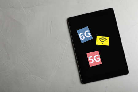 internet concept. Tablet with 5 and 6G cards, space for text on light gray table, top viewの写真素材