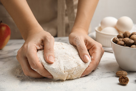 Woman kneading dough at white marble table, closeupの写真素材