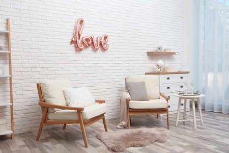 Cozy room interior with armchairs and balloon in shape of word Love. valentines day celebrationの写真素材