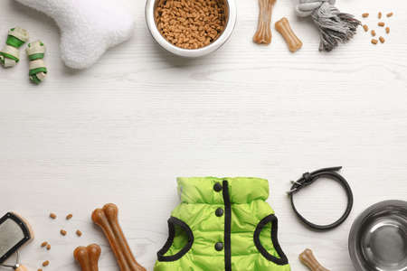 Flat lay composition with dog clothes, food and accessories on white wooden table. Space for textの写真素材