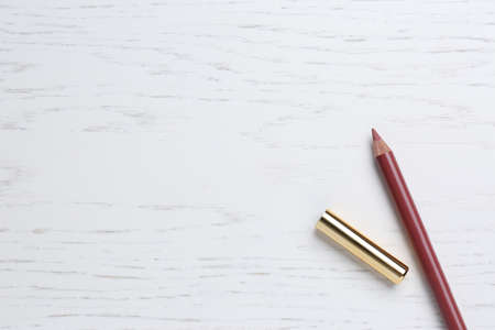 Lip pencil on white wooden table, flat lay with space for text. cosmetic product
