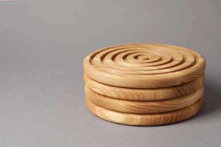 Stylish wooden cup coasters on light gray background, space for textの写真素材