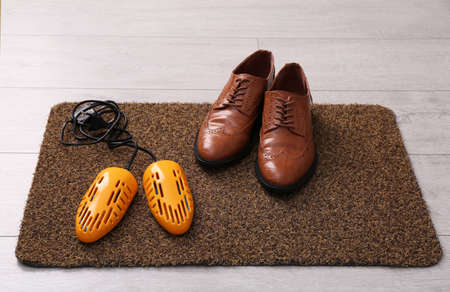 Shoes and electric dryer on rug indoorsの写真素材
