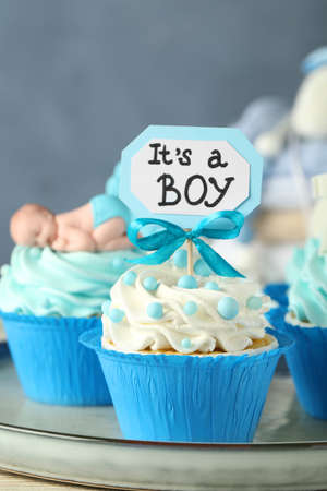 Beautifully decorated baby shower cupcakes for boy with cream on tray, closeup viewの写真素材