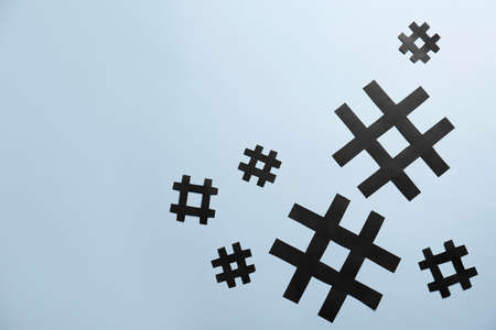 Paper hashtag symbols on light gray background, flat lay. Space for text