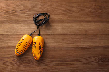 Electric shoe dryer on wooden background, top view. Space for textの写真素材