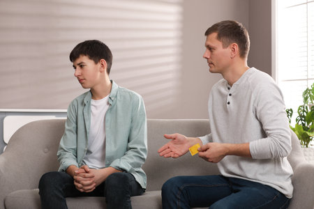 Father talking with his teenage son about contraception at home. sex education conceptの写真素材