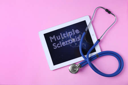 Multiple sclerosis concept. Flat lay composition with tablet and stethoscope on pink background
