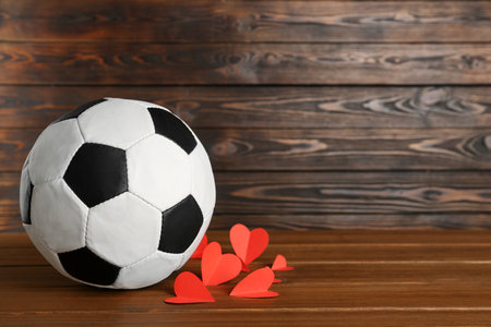 Soccer ball and hearts on wooden table. Space for textの写真素材