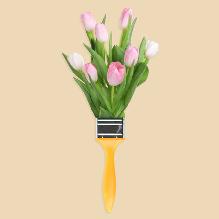 Creative design with paint brush and beautiful tulips on beige background. spring is comingの写真素材