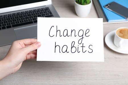 Woman holding paper note with phrase Break Bad Habits at table, closeupの写真素材