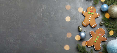 Flat lay composition with gingerbread men on gray table, space for text. banner designの写真素材