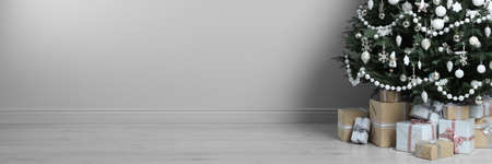 Beautifully decorated Christmas tree and gift boxes indoors, space for text. banner designの写真素材