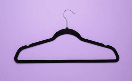 Empty clothes hanger on violet background, top viewの写真素材
