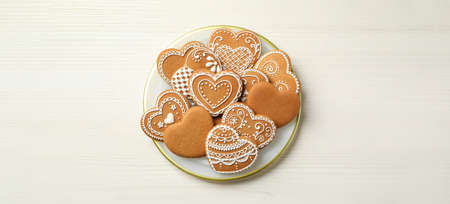 Tasty heart shaped gingerbread cookies on white wooden table, top view. banner designの写真素材
