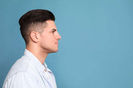 Profile portrait of man on light blue background. Space for textの写真素材