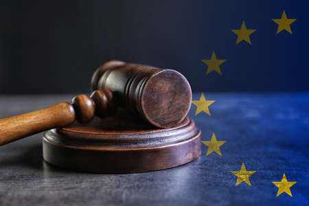 Double exposure of European union flag and judge's gavel on gray tableの写真素材