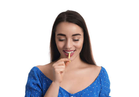 Beautiful young woman eating french fries on white backgroundの写真素材
