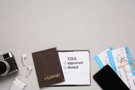 Flat lay composition with passport, tickets and earphones on light gray background, space for text. Visa receivingの写真素材