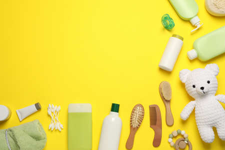 Flat lay composition with baby cosmetic products on yellow background, space for textの写真素材