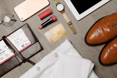 Flat lay composition with clothes, shoes and accessories on wooden background. Packing for business tripの写真素材