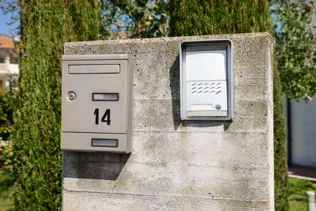 Mail box and intercom on gray concrete wall outdoors