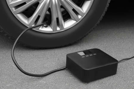 Inflating car tire with portable air pump outdoorsの写真素材