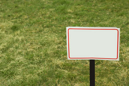White blank signboard on green grass. Space for textの写真素材