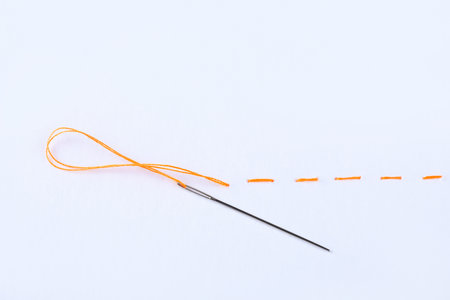 Yellow embroidery and needle on white backgroundの写真素材