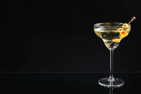 Martini cocktail with olives on dark background, space for textの写真素材