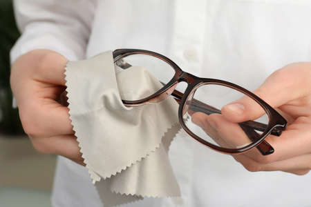 Woman cleaning glasses with microfiber cloth, closeupの写真素材