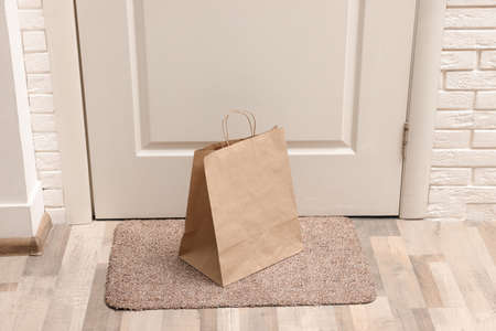 Paper bag on door mat near entrance indoorsの写真素材