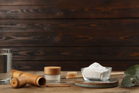 Composition with tooth powder and eucalyptus on wooden table, space for textの写真素材