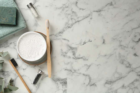 Flat lay composition with tooth powder and brushes on white marble table. Space for textの写真素材