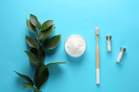 Bowl of tooth powder, brush, dental flosses and plant on turquoise background, flat lay. Space for textの写真素材