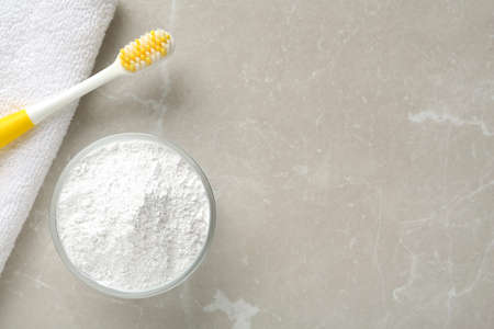 Tooth powder, brush and towel on light gray marble table, flat lay. Space for textの写真素材
