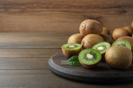 Fresh ripe kiwis on wooden table, space for textの写真素材