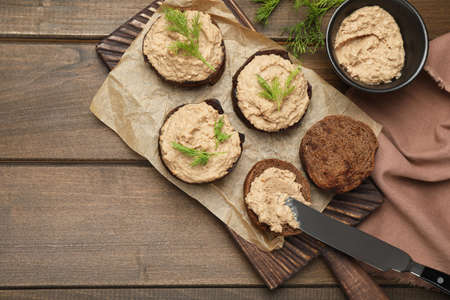Slices of bread with delicious pate on wooden table, flat layの写真素材