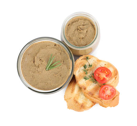 Glass jars with tasty liver pate, bread and tomato on white background, top view