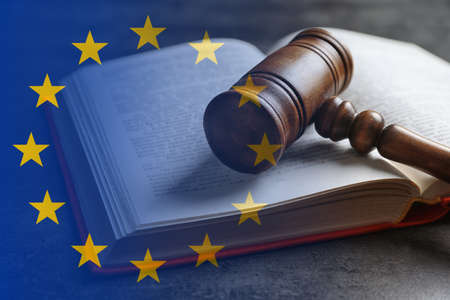 Double exposure of European union flag and book with wooden gavel on gray tableの写真素材