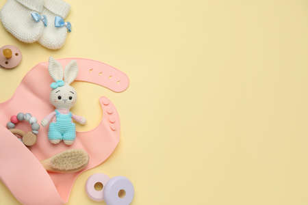 Flat lay composition with baby accessories and bib on yellow background, space for textの写真素材